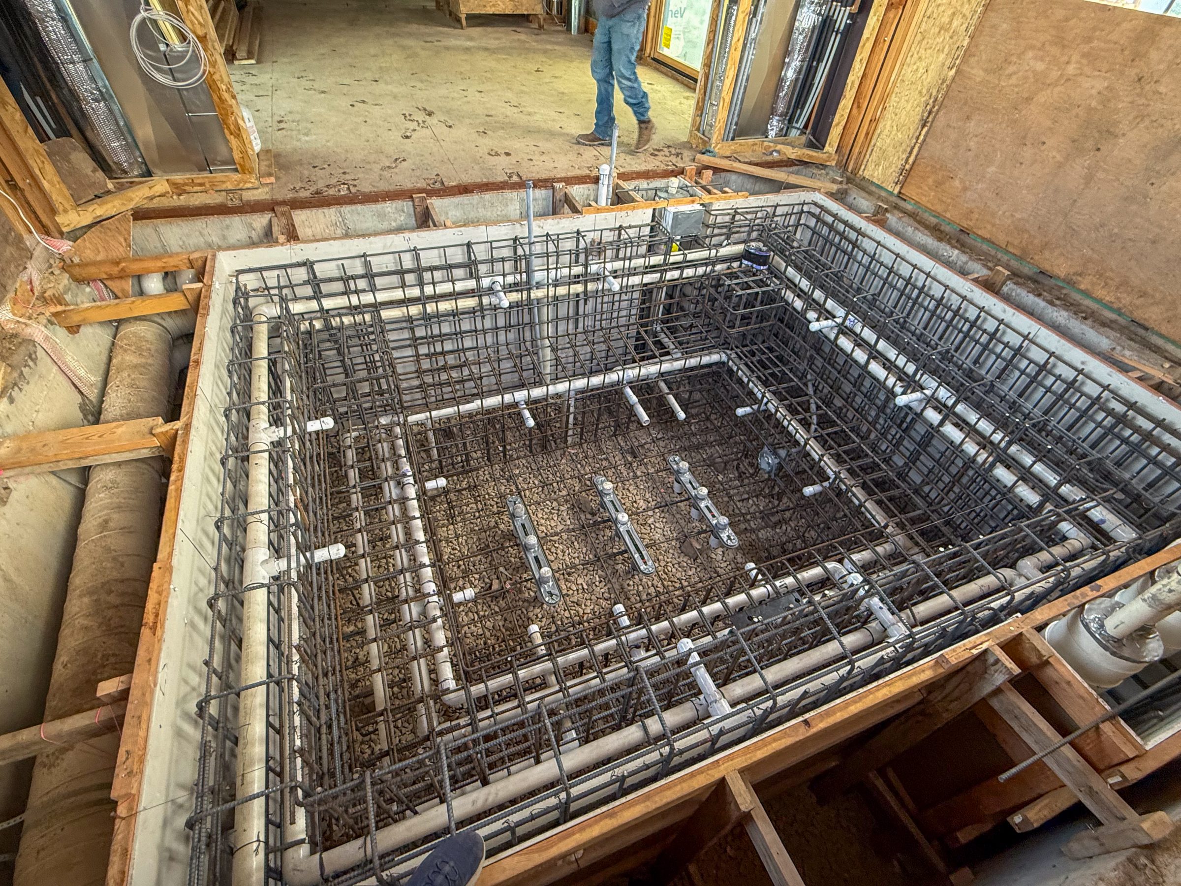House construction with plumbing and rebar setup.