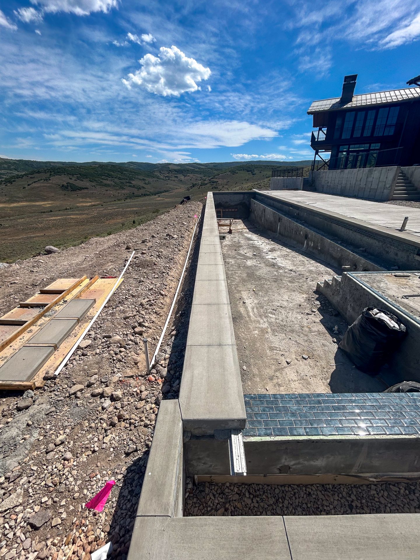 Concrete pool construction with scenic mountain view.