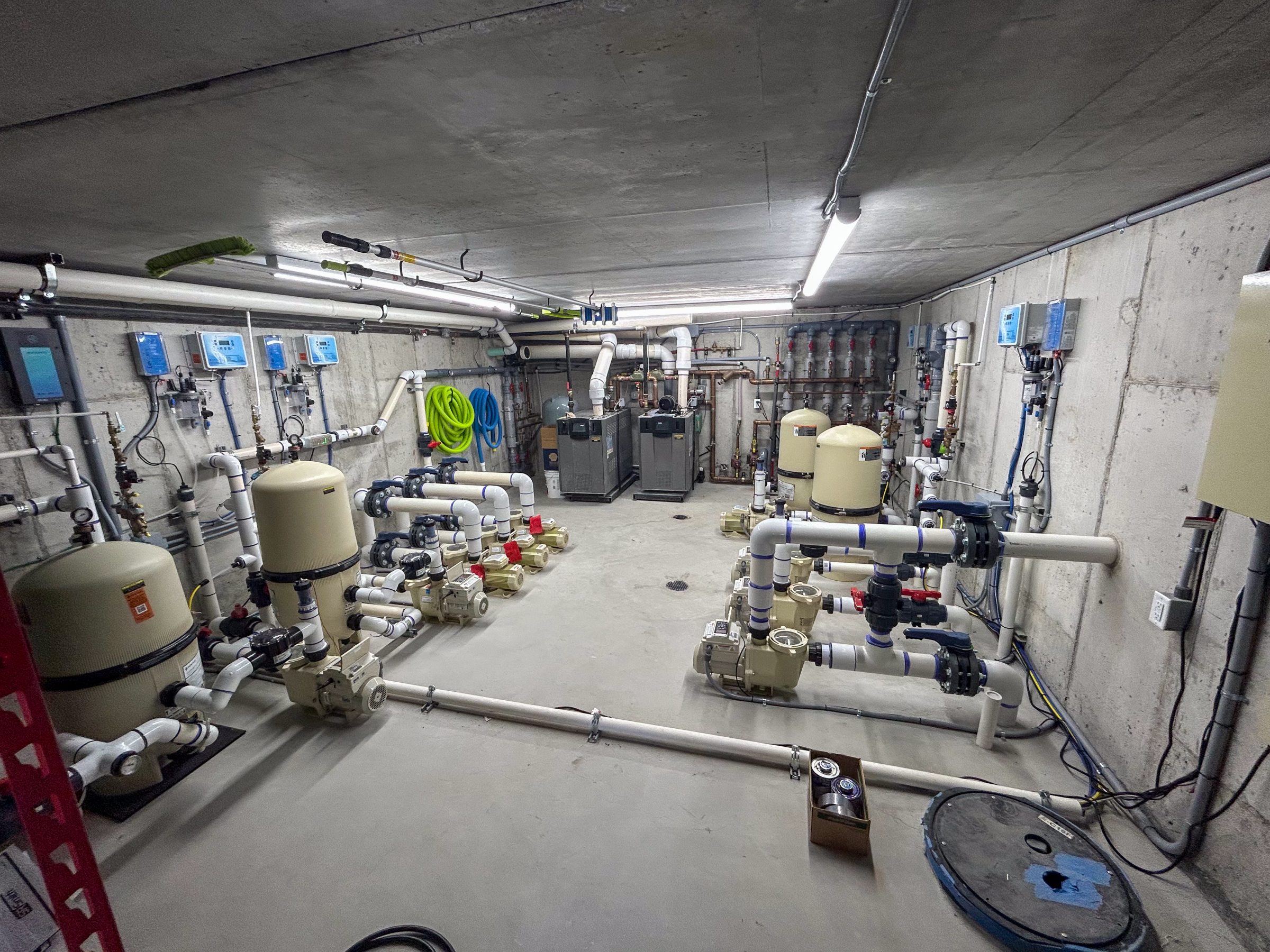 Industrial plumbing room with pipes and filtration systems.