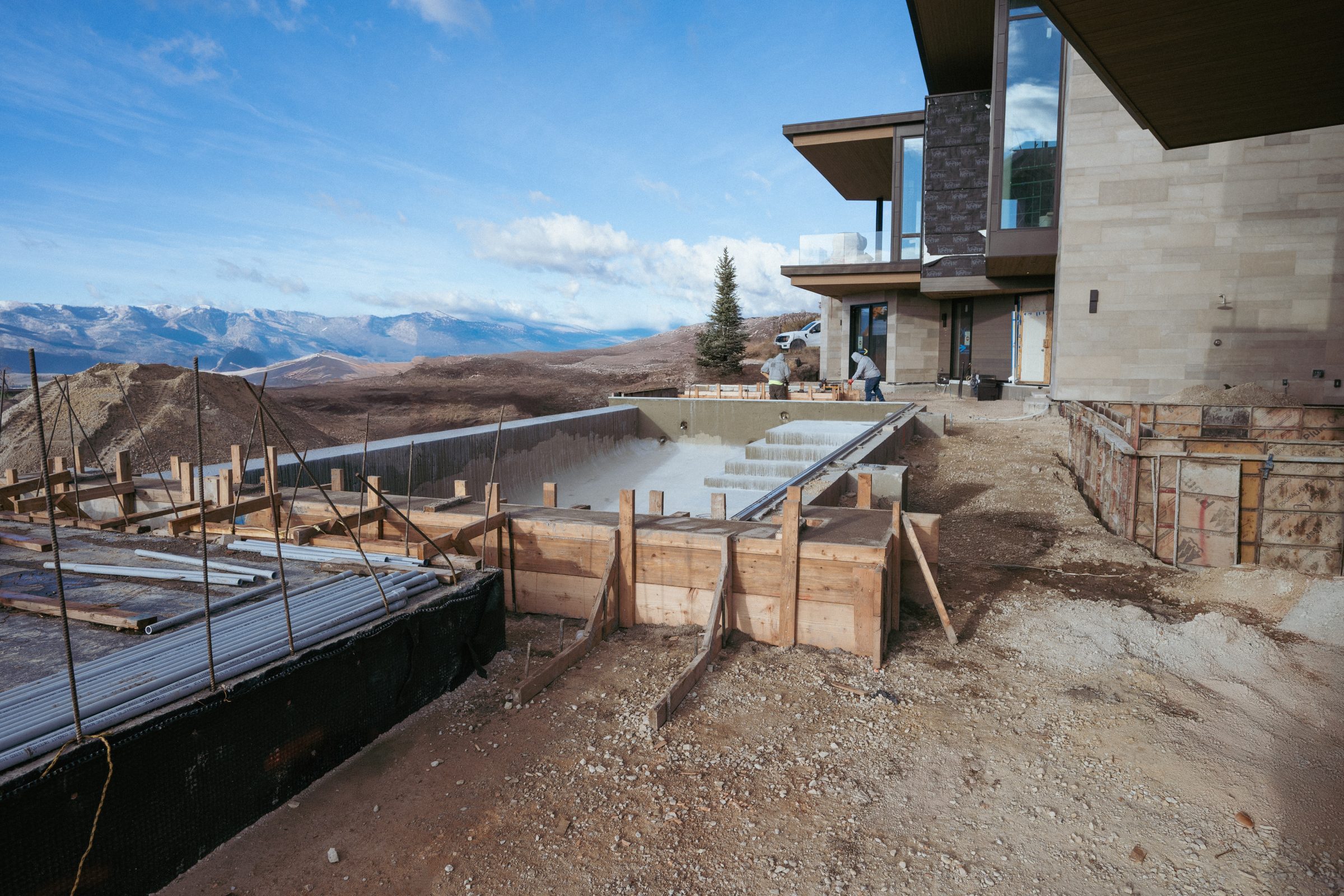 House with unfinished patio construction, mountain view.