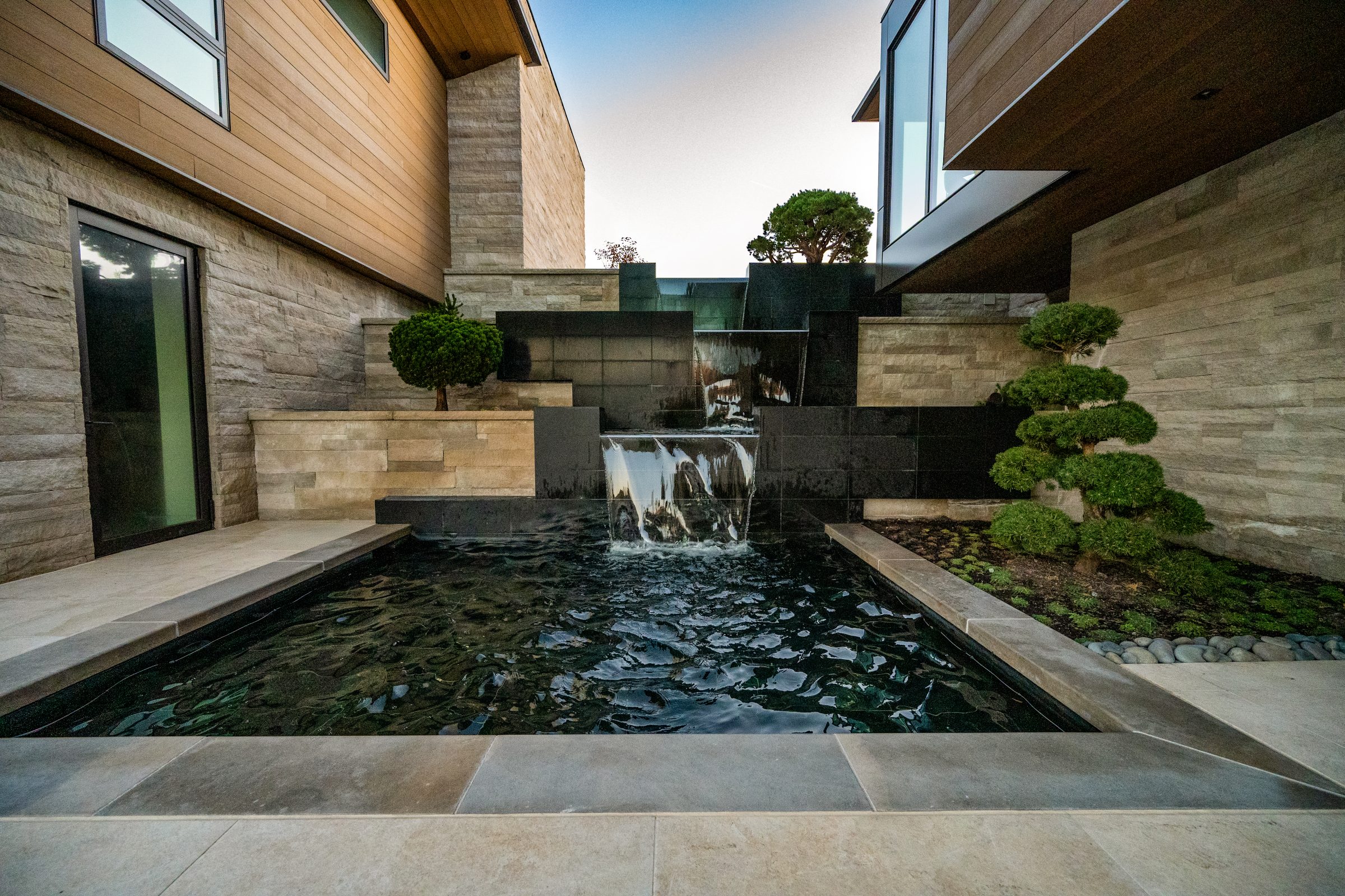 Modern house courtyard with waterfall and pool