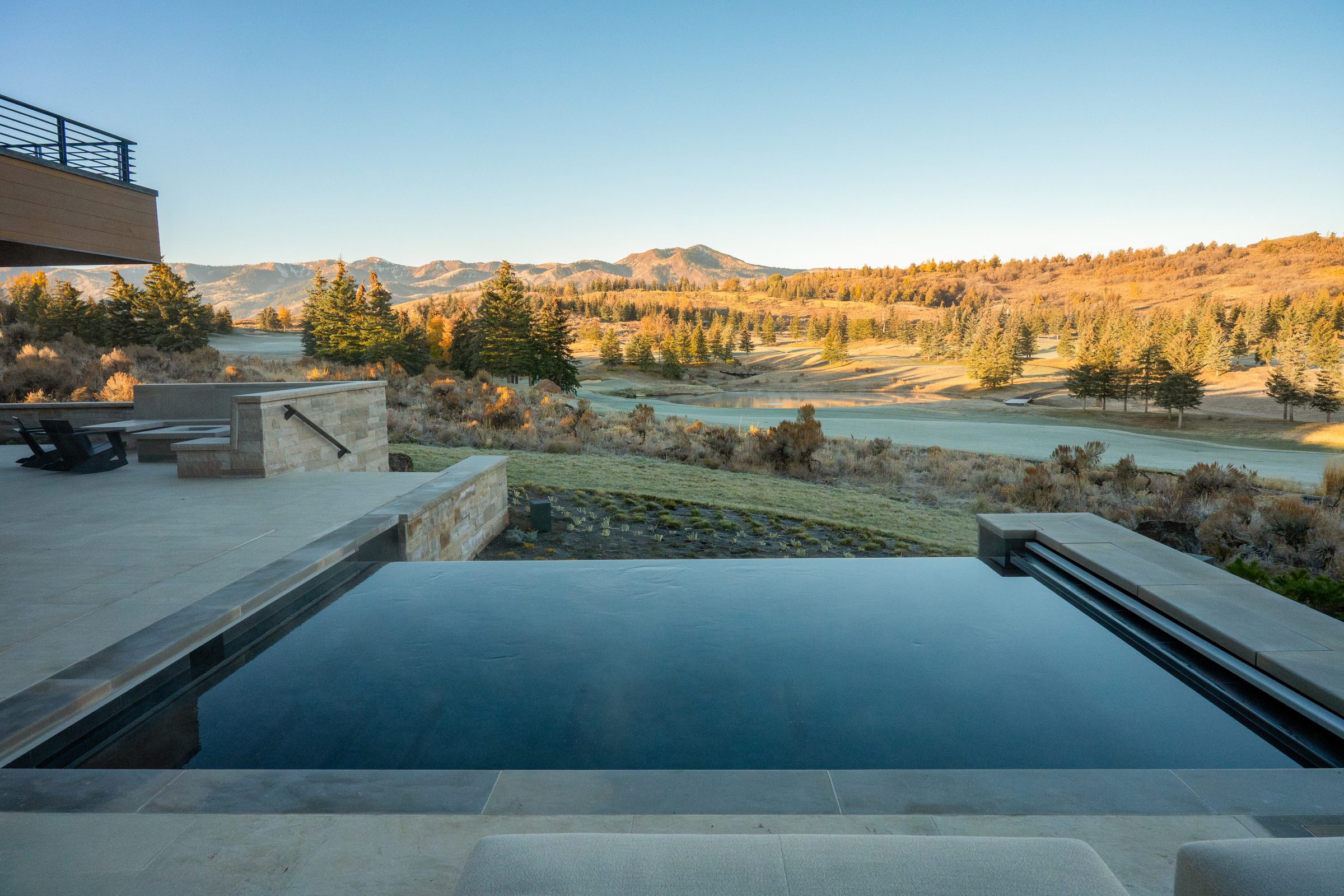 Infinity pool overlooking mountain landscape at sunset.