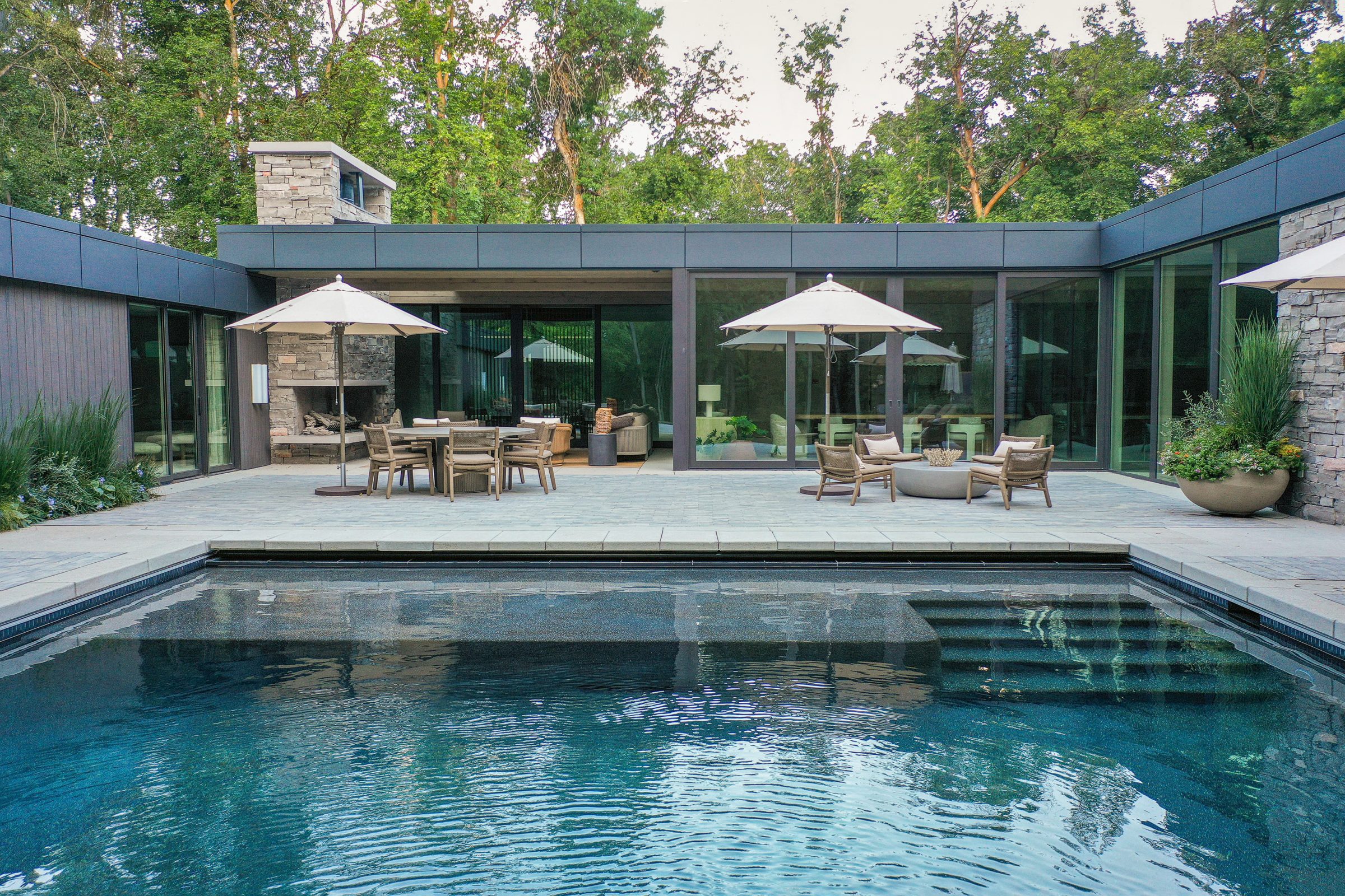 Modern patio with pool and outdoor seating area.