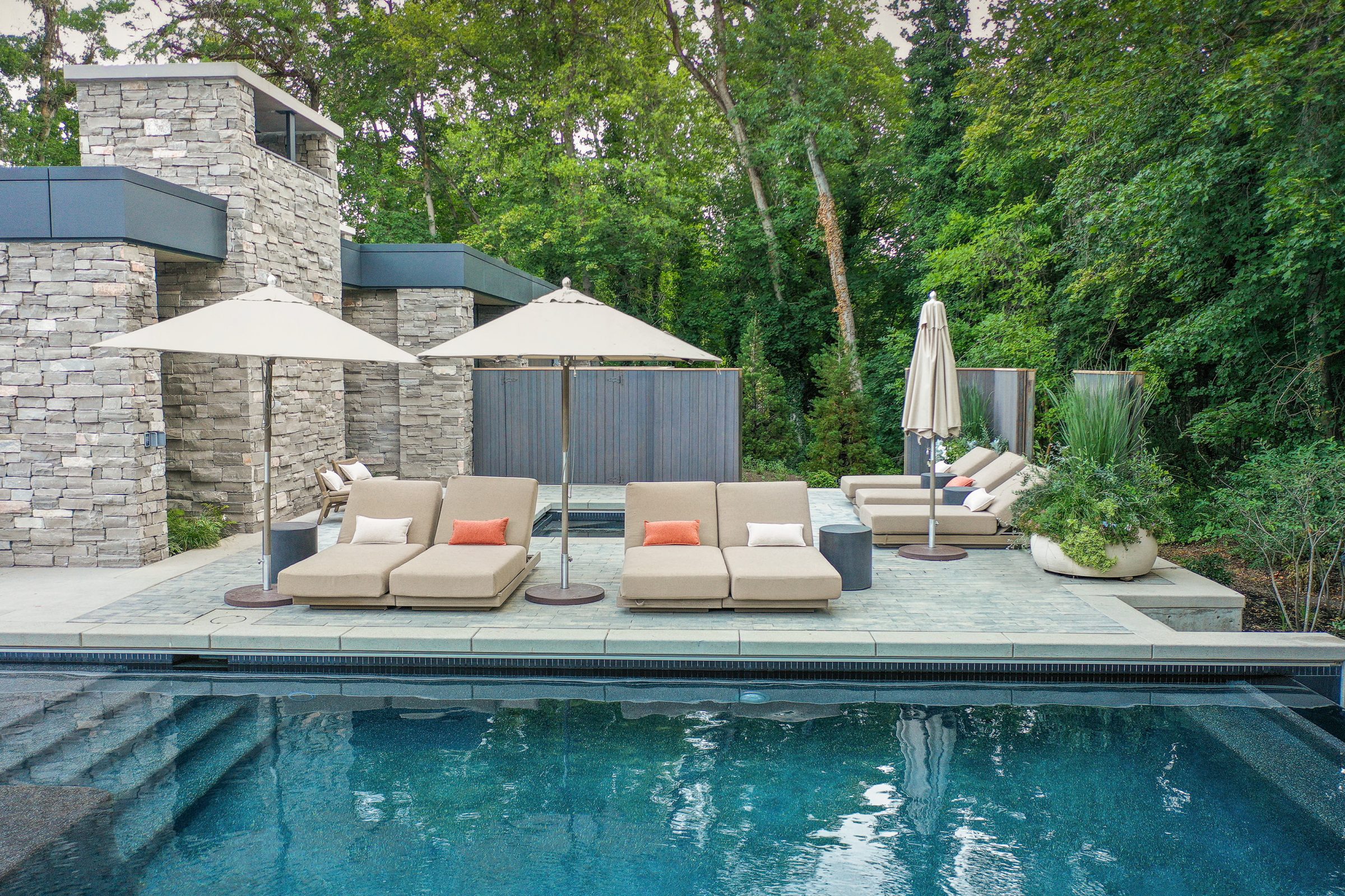 Luxurious outdoor pool with lounge chairs and umbrellas.